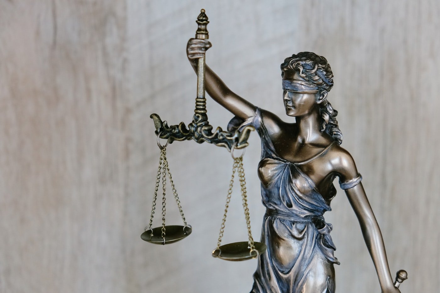 Estátua da Justiça em bronze segurando a balança, símbolo do Direito Penal